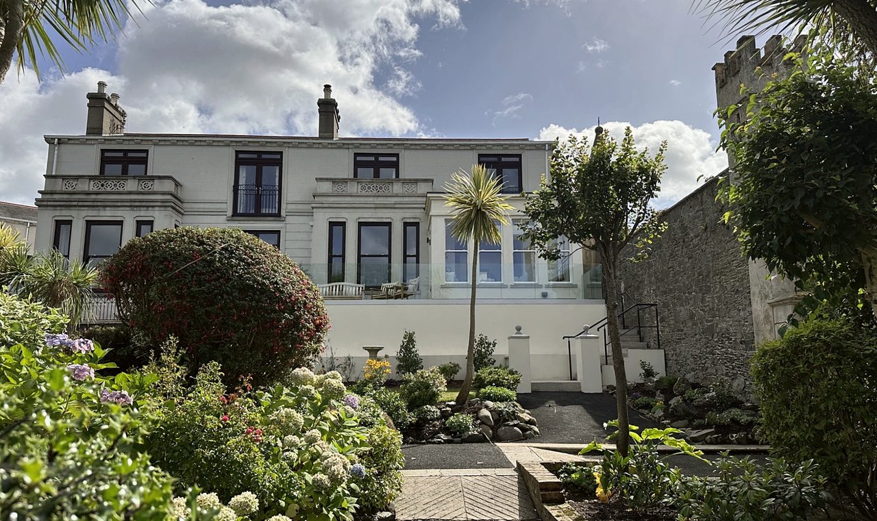 Two-storey house with a single-storey rear extension and terrace above a planted garden