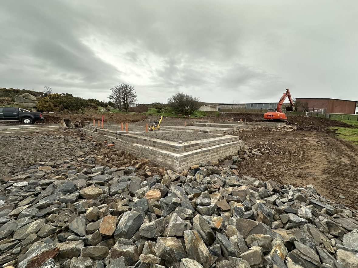 Site with stone hardcore and new foundations under construction