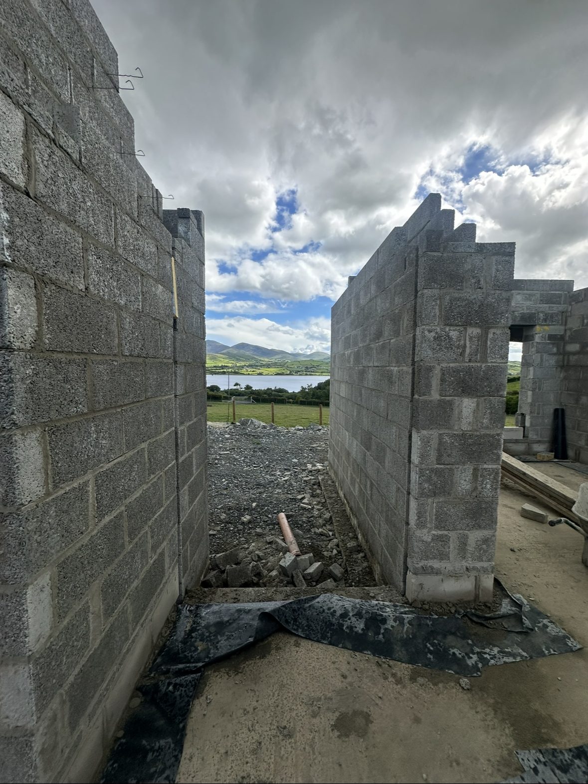 Narrow view between new blockwork walls toward the landscape